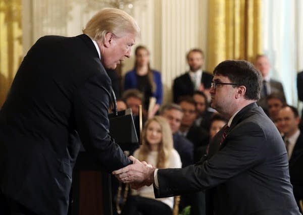 Trump shakes hand with acting VA secretary Robert Wilkie.