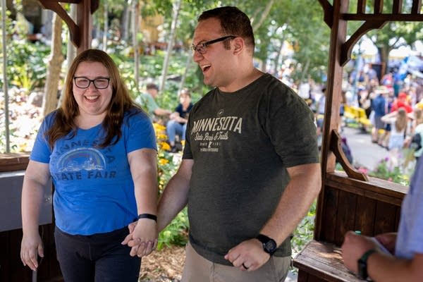 Two people smile and hold hands