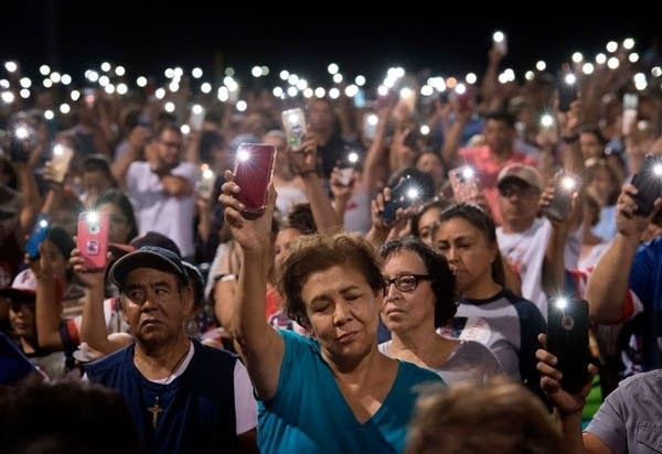 TOPSHOT - People hold up their phones during a prayer and candle vigil organized by the city, after a shooting left 20 people dead at the Cielo Vista Mall Wal-Mart in El Paso, Texas, on August 4, 2019. - A shooting at a Walmart store in Texas left multiple people dead. At least one suspect was taken into custody after the shooting in the border city of El Paso, triggering fear and panic among weekend shoppers as well as widespread condemnation. It was the second fatal shooting in less than a week at a Walmart store in the US and comes after a mass shooting in California last weekend. (Photo by Mark RALSTON / AFP)        (Photo credit should read MARK RALSTON/AFP/Getty Images)