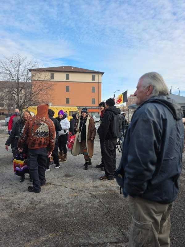 A group of people gathers in a parking lot.