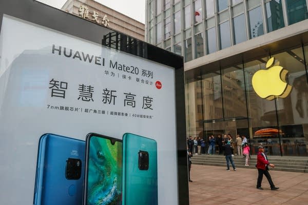 A Huawei poster is displayed outside an Apple store in Shanghai in 2018. 