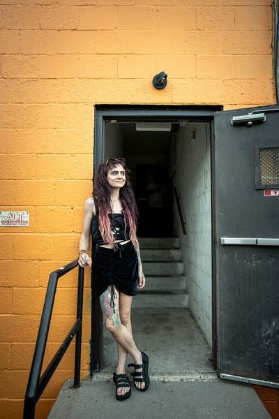 A person stands by a doorway at an outdoor social event