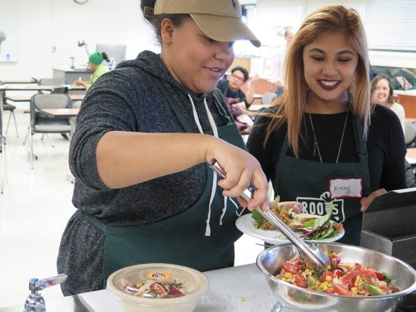 Krystal and Alexus are tasting salads created by other students.