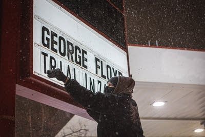 A man adds lettering to a sign