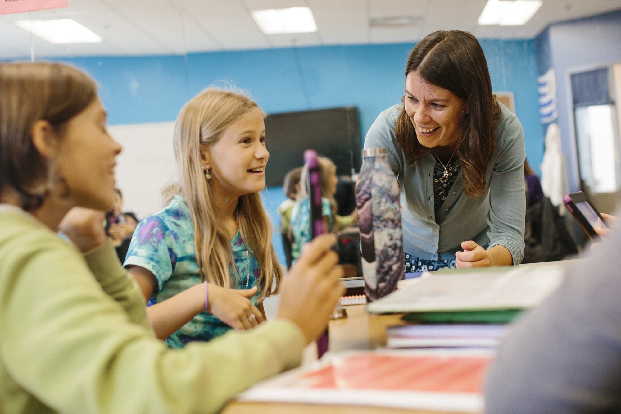 Teacher Cecilia Delbene works with two students