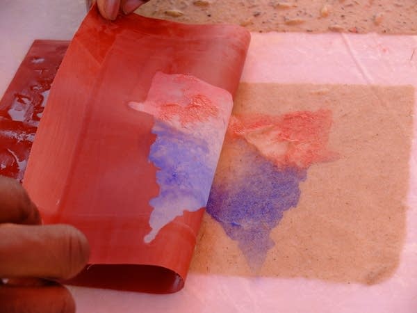 Colored paper pulp is used to make images on freshly made paper.