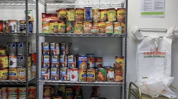 Food items line the shelf at a food pantry in South Florida.