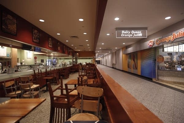 Chairs are stacked on top of each other in an empty restaurant. 