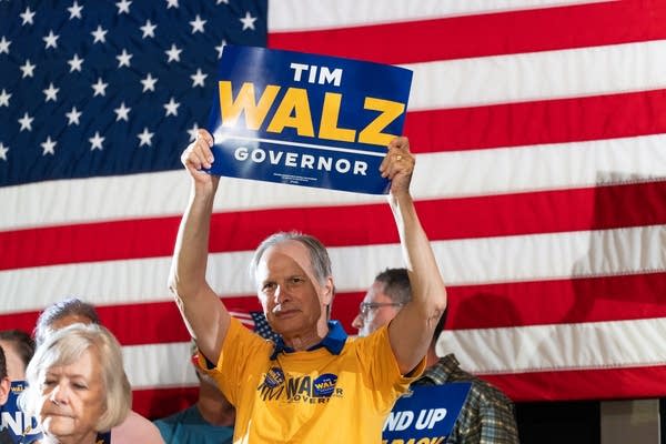 Person holding tim walz sign