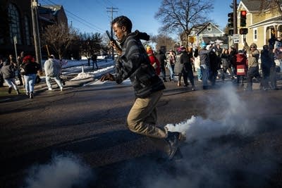 A man runs from tear gas