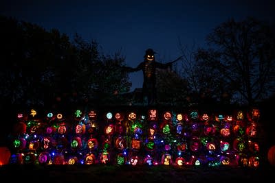 An elaborate Halloween display with dozens of lit pumpkins