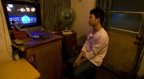 A Chinese man watches the opening ceremony of the 29th Olympic games at home on August 8, 2008 in Beijing, China.