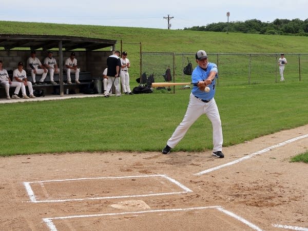 a man hits a ball with a bat 