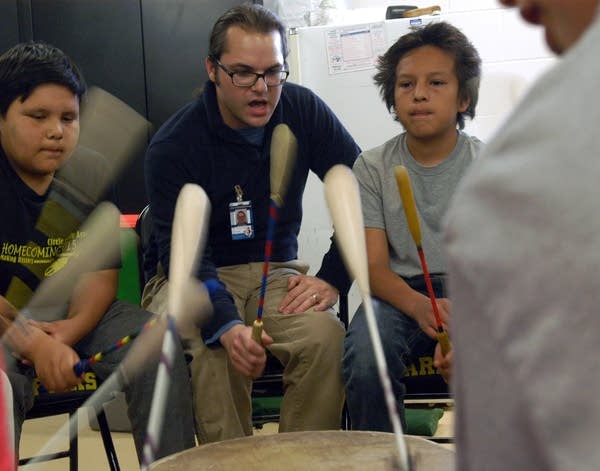 Teacher Ryan Bajan drums with students, including Kai Chavez, right.