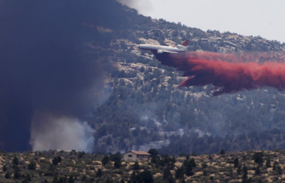 An aerial tanker drops fire retardant