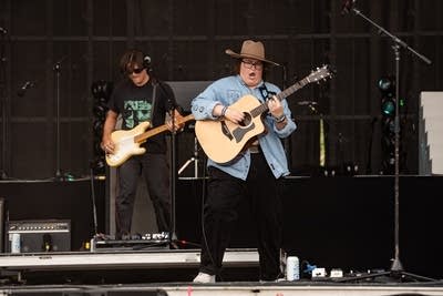 Two musicians performing on a large outdoor stage