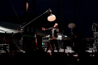 Francis and the Lights performing on an outdoor stage.