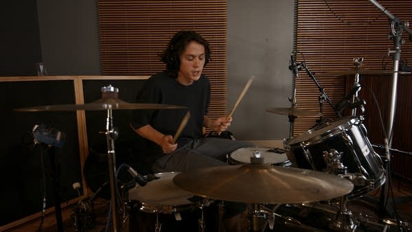 A drummer performing in a recording studio
