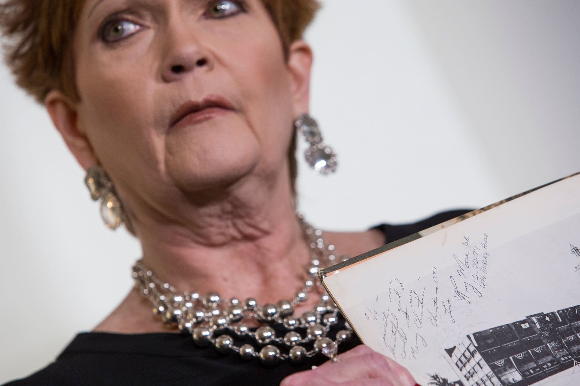 Beverly Young Nelson holds up a picture showing a message from Roy Moore.