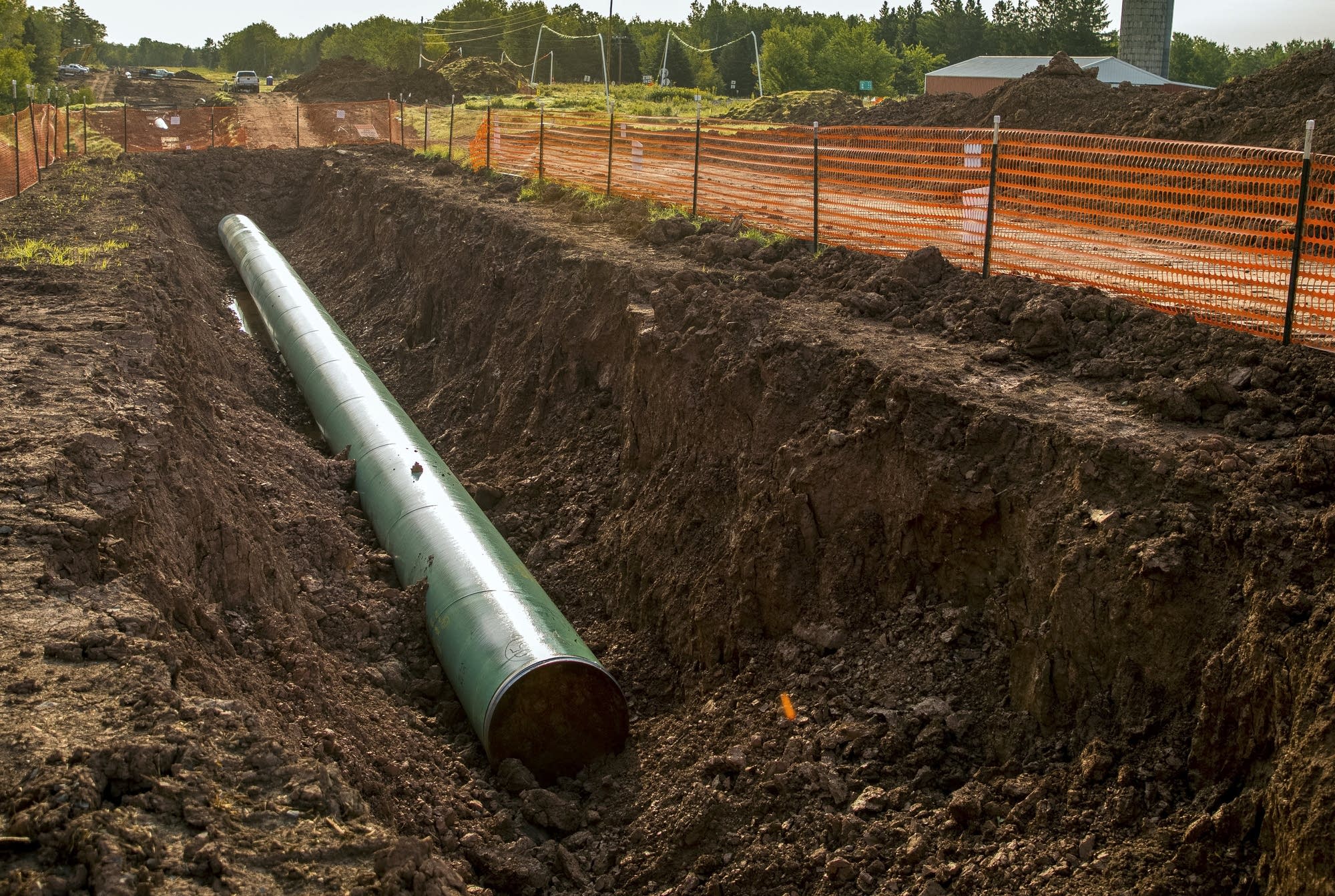 A new section of pipeline sits across the street from a farm.