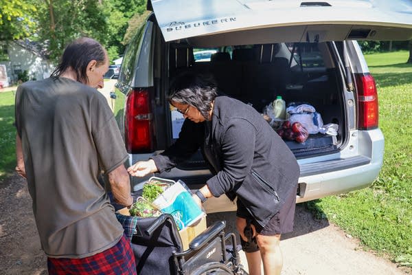 Two people putting groceries into a vehicle