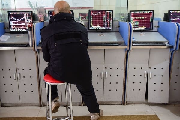 An investor looks at a screen showing stock market movements at a securities company in Fuyang in China's eastern Anhui province on January 23, 2020.  (Photo by STR/AFP via Getty Images)