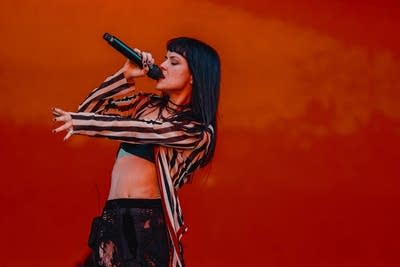 A musician sings on a large outdoor stage