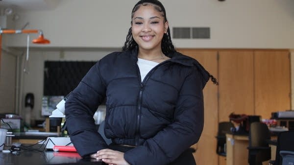 A young woman smiles in a college lab.