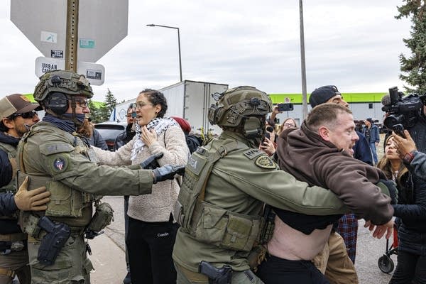 Officers in tactical gear while standing near a van.