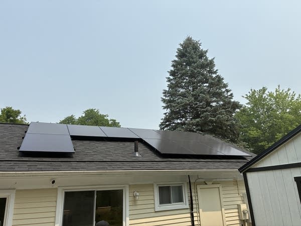 Ten solar panels newly installed on the roof of this yellow house is expected to save up to $1000 per year on utility bills.
