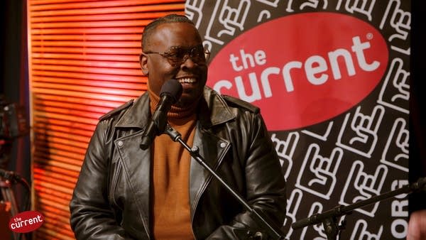 A man speaks during a conversation in front of an audience 
