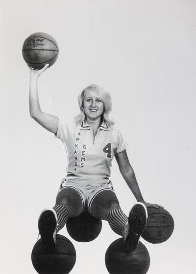 A woman poses with a basketball