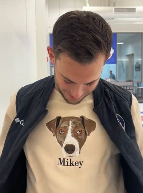 A man wears a shirt with a portrait of his dog