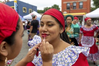 A person helps another person put on makeup. 