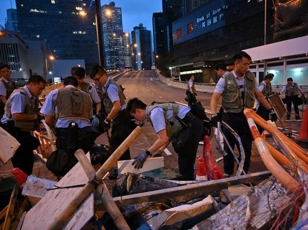 Police officers dismantle barricades placed earlier by demonstrators.