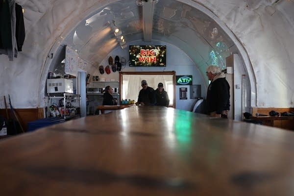 A shot of a bar inside the igloo with people sitting near the bar.