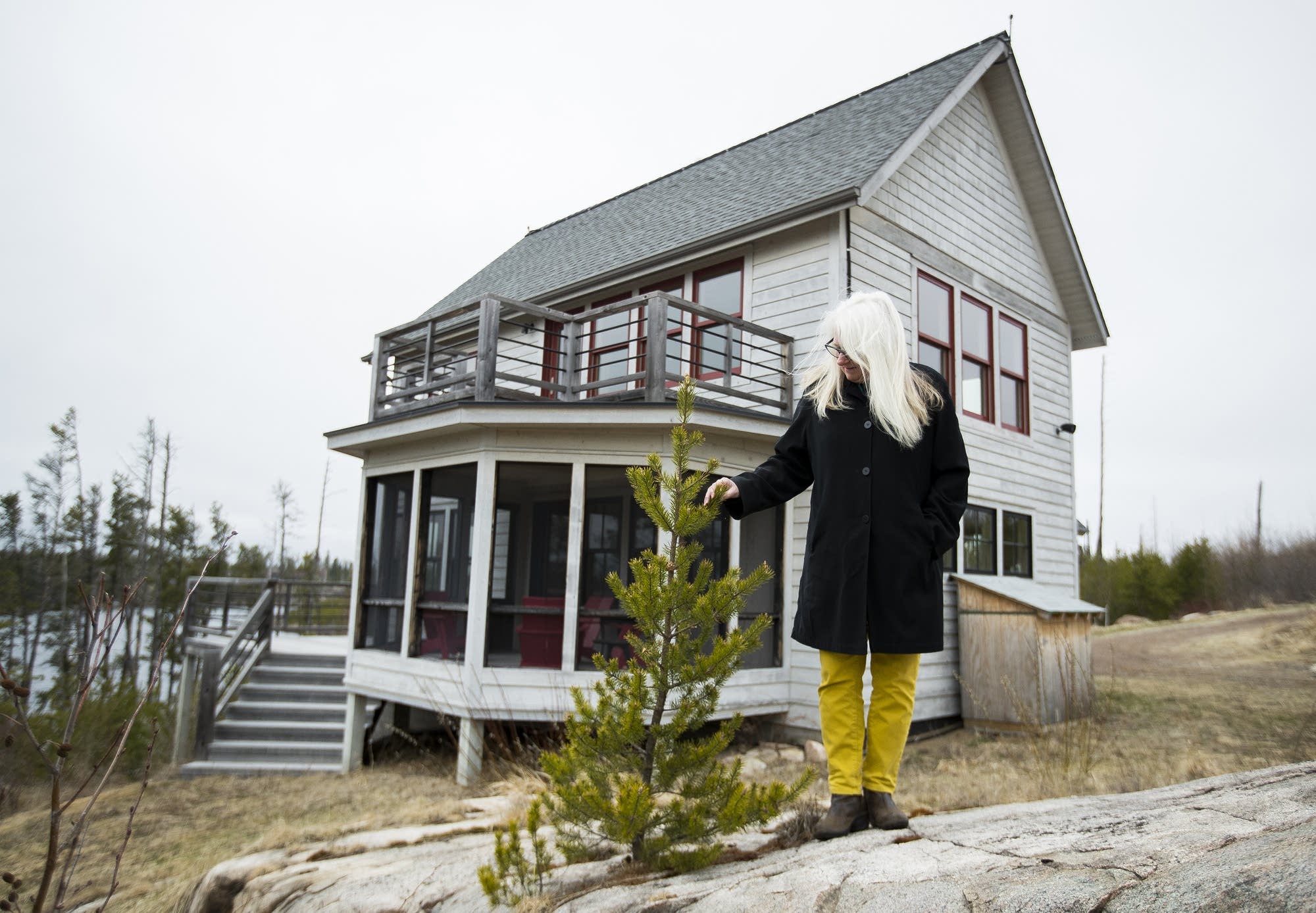 Jan Siverston stands in front of her new cabin, rebuilt after the fire.