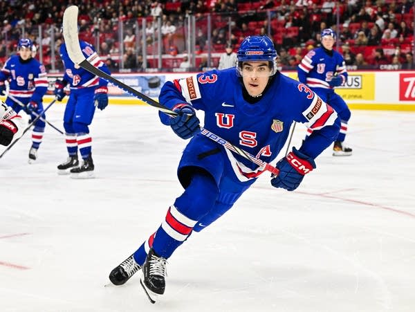 A hockey player skates down the rink during a game