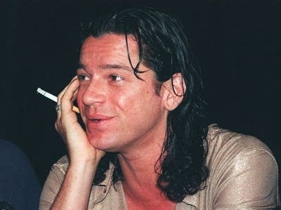 A man talking while holding a cigarette (don't smoke, kids)
