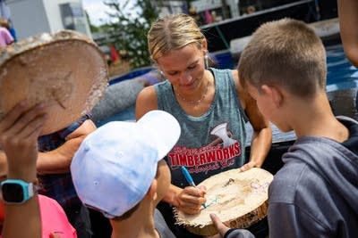 A woman signs a wood chip