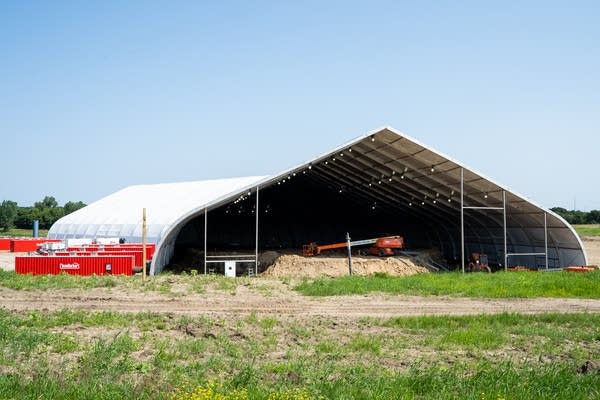 Ventilation units filter the air from a temporary shelter covering a hazardous waste pit.