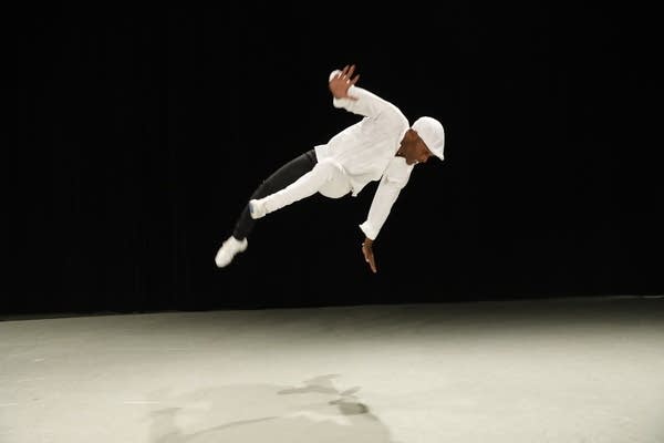 still of a man in the air, dancing on a stage