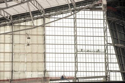 Construction workers hang from scaffolding