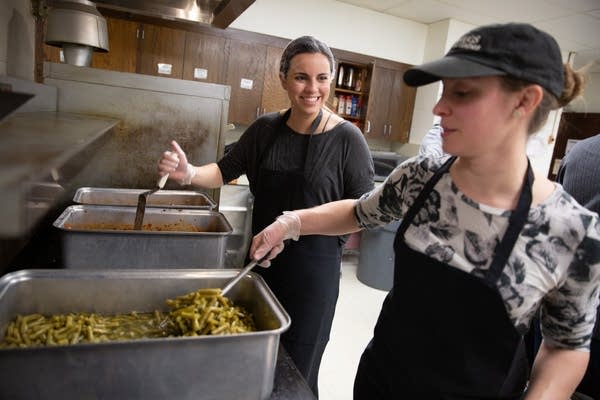 Hannah Litfin (left) and Rachel Friesen prepare hot meals.