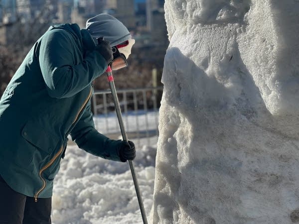 person carving snow sculpture