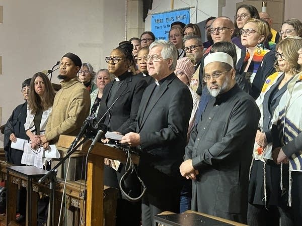 Clergy members stand behind a podium