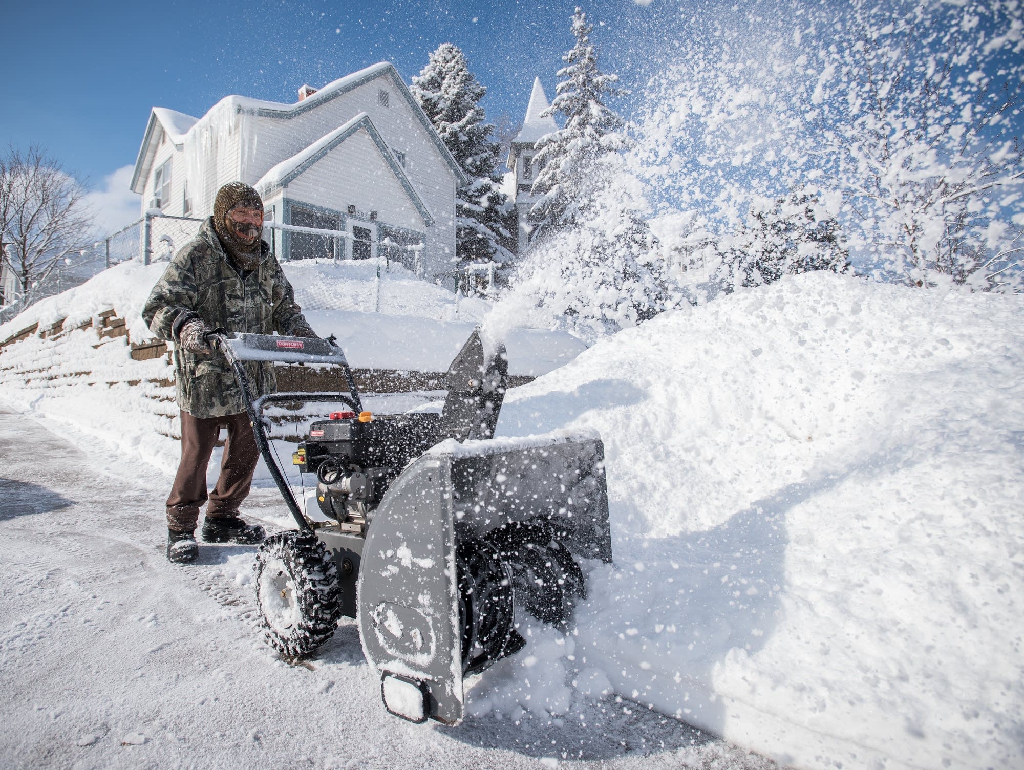 Tong Vang, 33, uses a snowblower