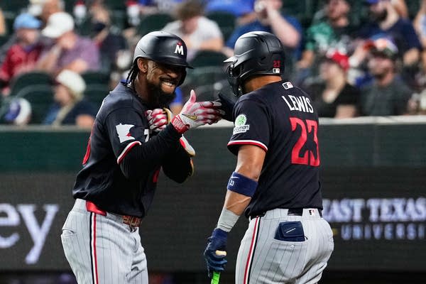 Byron Buxton,Royce Lewis fist bump in navy baseball jerseys