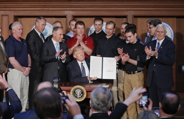 President Donald Trump holds up signed Energy Independence Executive Order