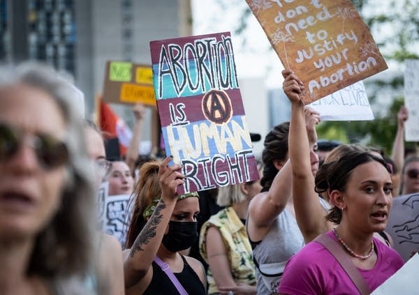 Protesters hold signs